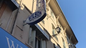 A building with a sign reading "Wilson Square" and another sign for "El Wilson Square Hotel." - Wilson Square (Toulouse)