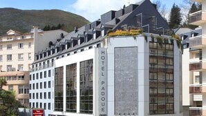 A modern hotel with large windows and a prominent sign for the hotel.