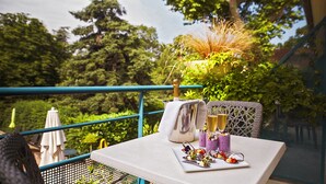 A table set outdoors with a bottle of champagne, glasses, and a plate of food. - Hôtel Mercure Castres L'Occitan (Castres)
