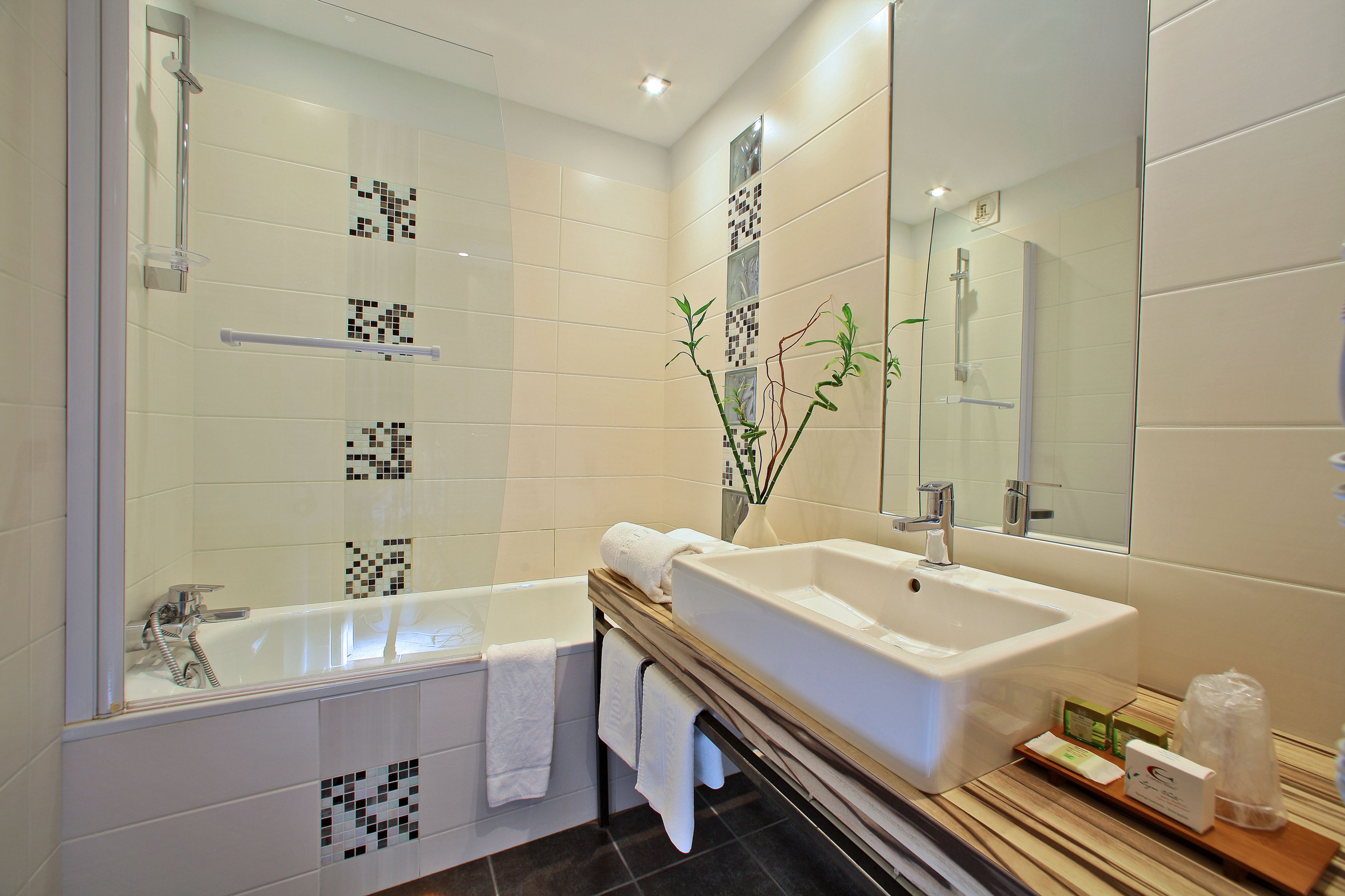 Un baño moderno con bañera, lavamanos grande y espejo.