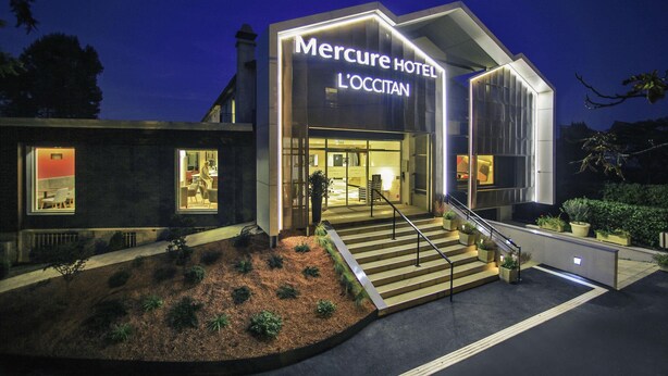 A modern hotel with a prominent entrance, a staircase leading to the lobby, and a well-lit facade. - Hôtel Mercure Castres L'Occitan (Castres)