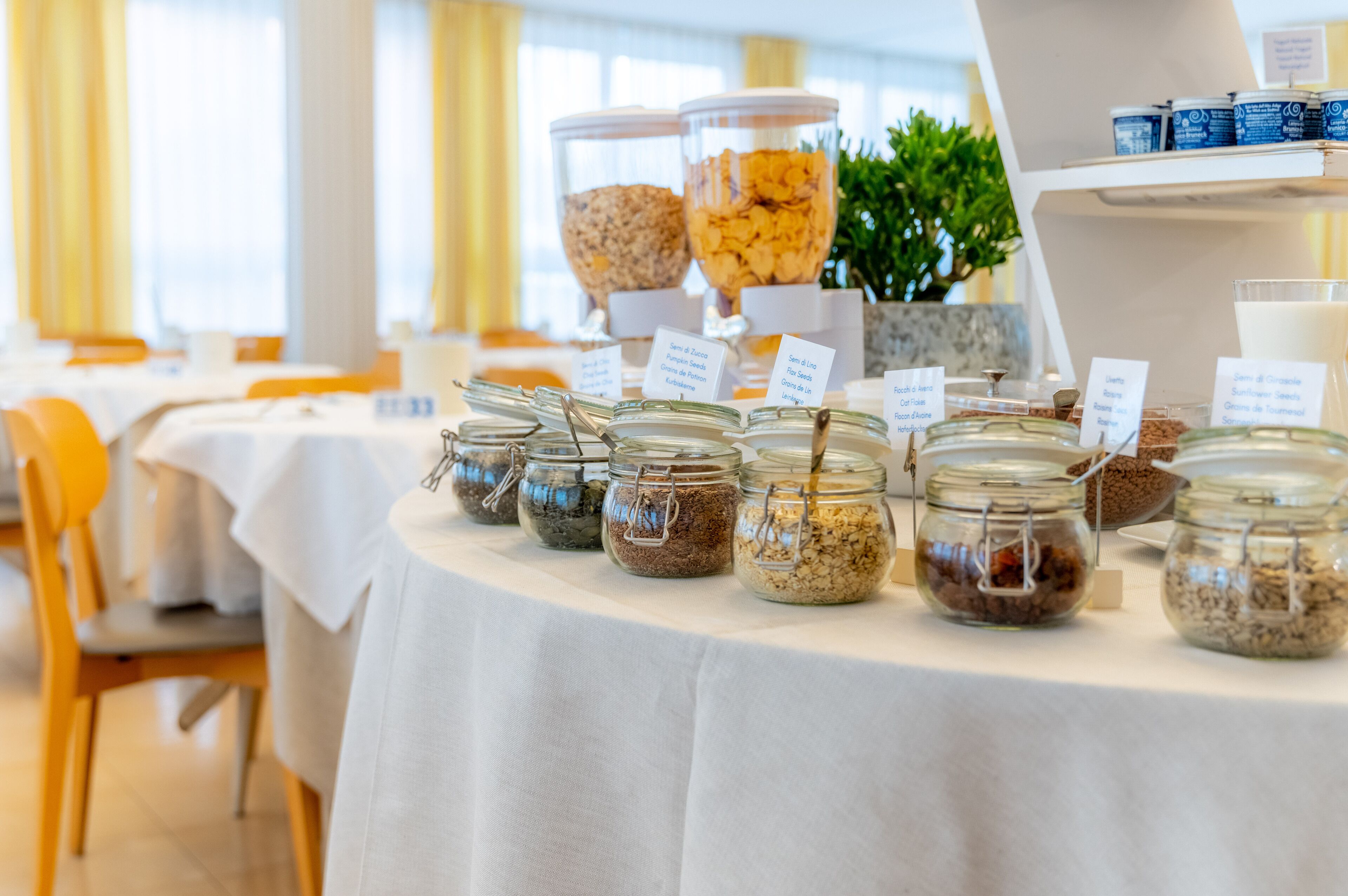 A buffet table with various food items in jars and containers, labeled with names.