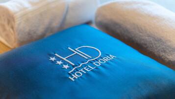Ein blaues Kissen mit eingesticktem Logo "HD HOTEL DORIA".