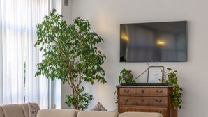 Una sala de estar moderna con un sofá, una mesa de centro y un televisor montado en la pared.