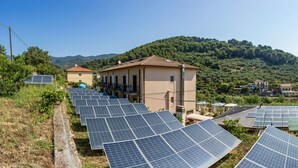 Zonnepanelen, een gebouw en een helling.