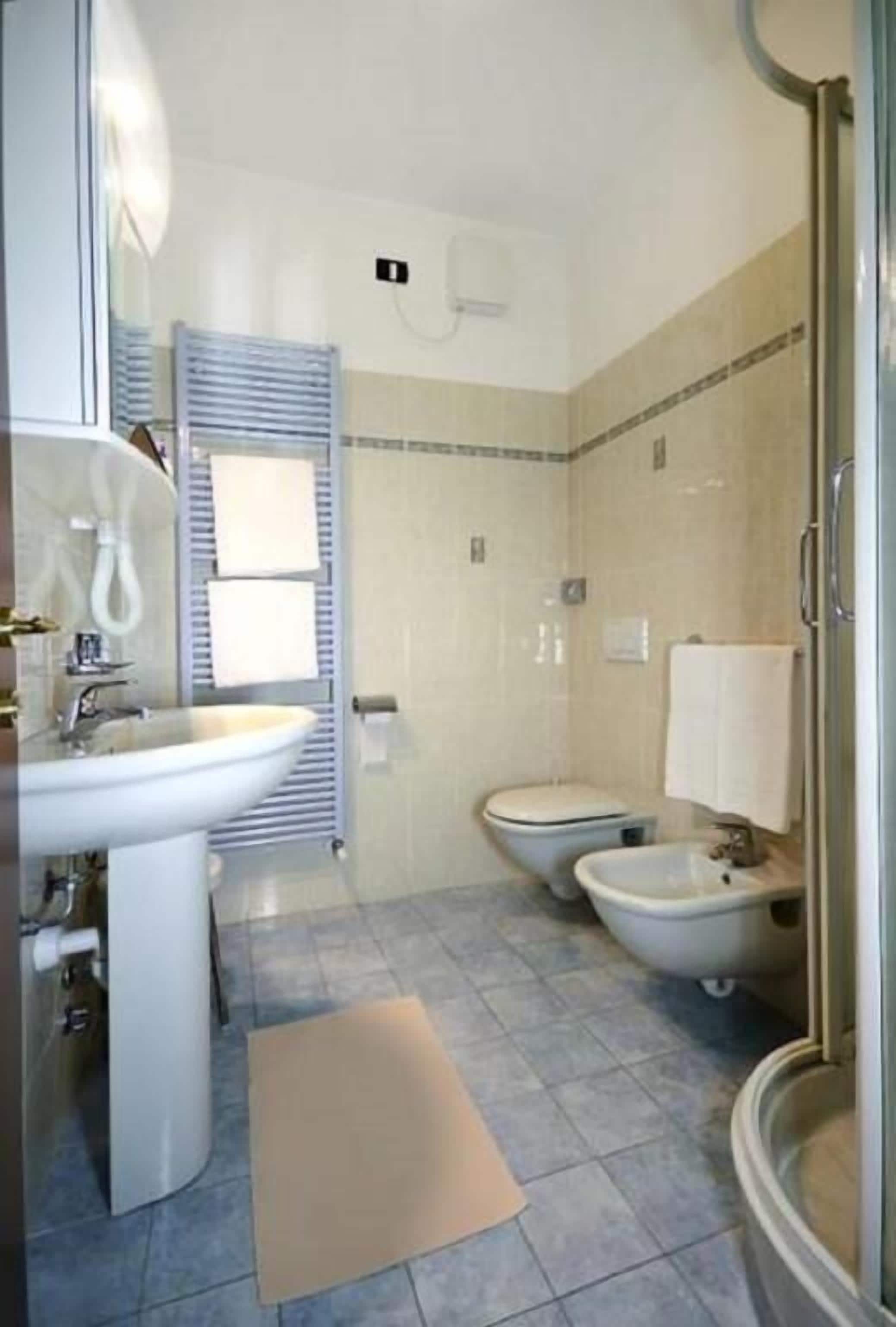 Un bagno con lavandino, WC, bidet e doccia.
