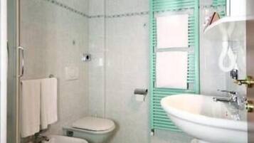 A bathroom with a toilet, bidet, and sink.