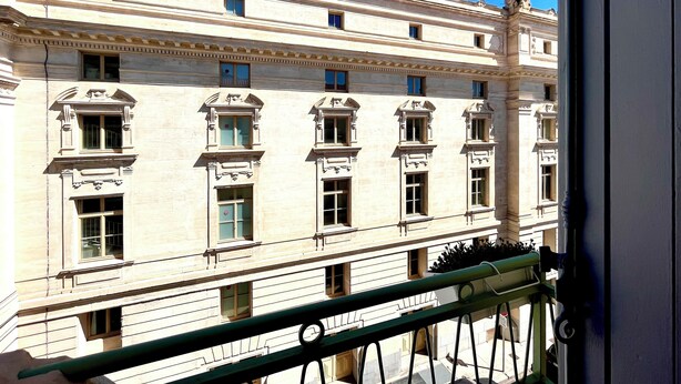 A classical building with multiple windows and a balcony. - Hôtel Le National (Sète)