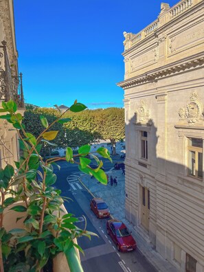 A narrow street with parked cars and a building with classical architecture. - Hôtel Le National (Sète)