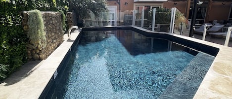 Una piscina al aire libre de temporada, sillones reclinables de piscina