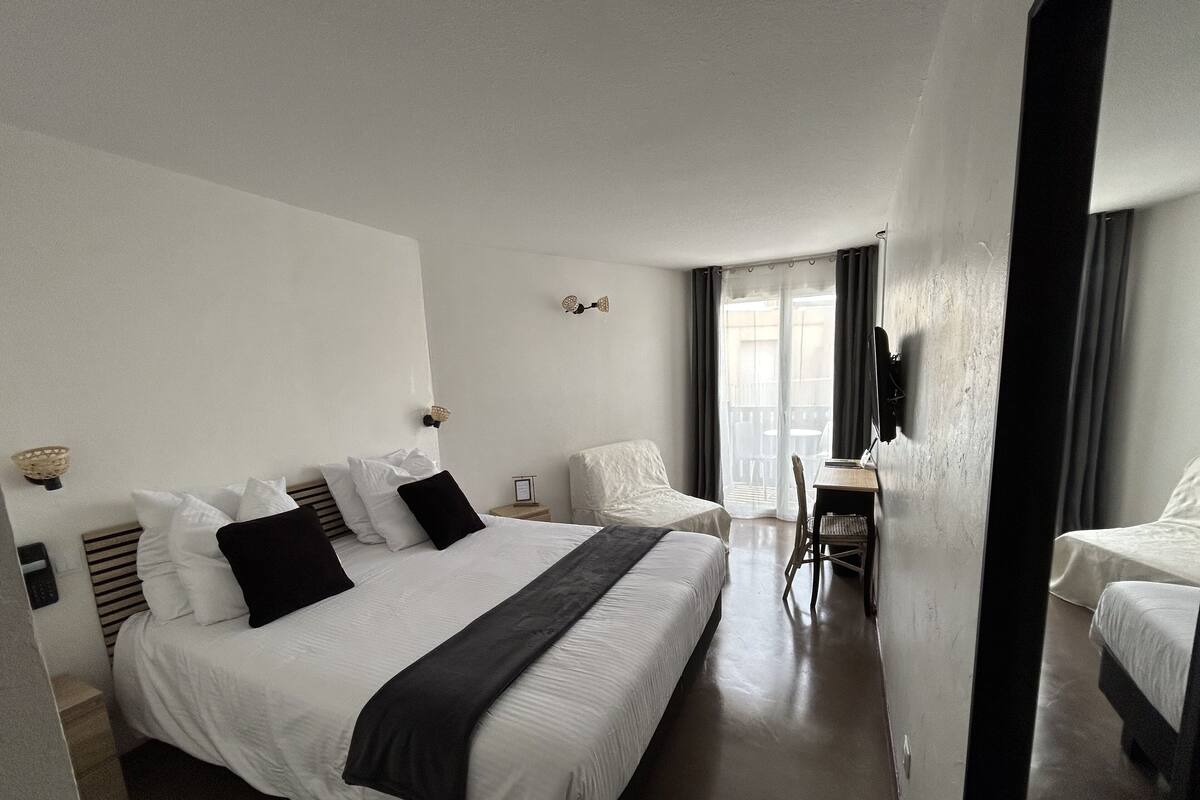 Una habitación de hotel con una cama grande, un escritorio y una silla.