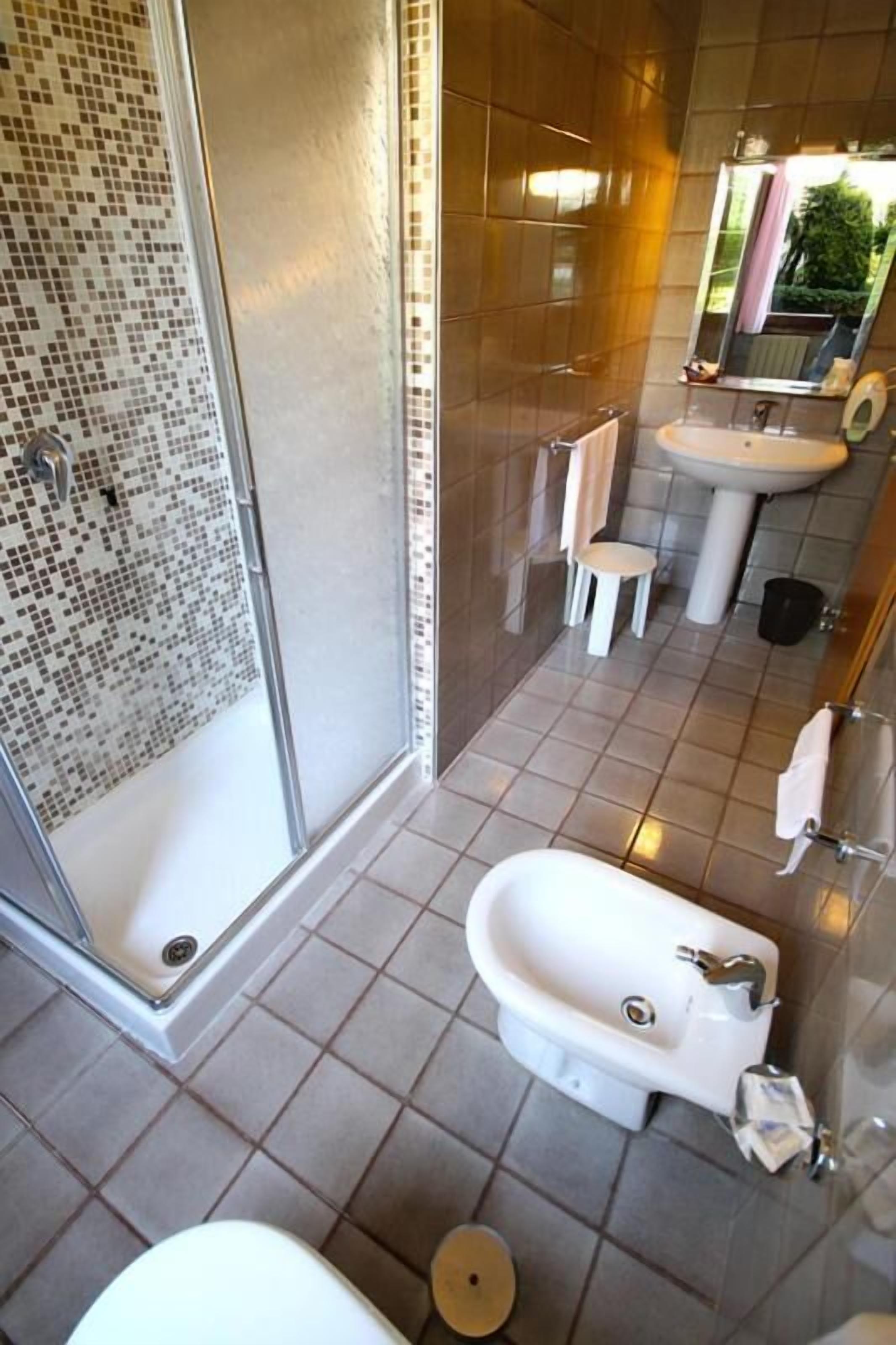 Un baño con ducha, bañera, inodoro y lavabo.
