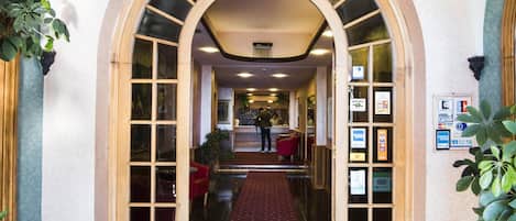 A hallway with an arched ceiling, a patterned carpet, and a reception desk.