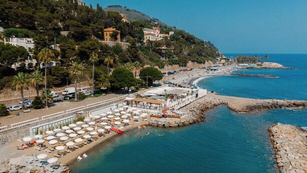 A coastal hotel with beachside rooms, a rocky shoreline, and a view of the sea. - Hotel Kristina (Imperia)