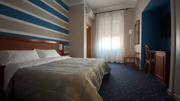 Ein Hotelzimmer mit einem großen Bett, einem Schreibtisch und einem Stuhl.