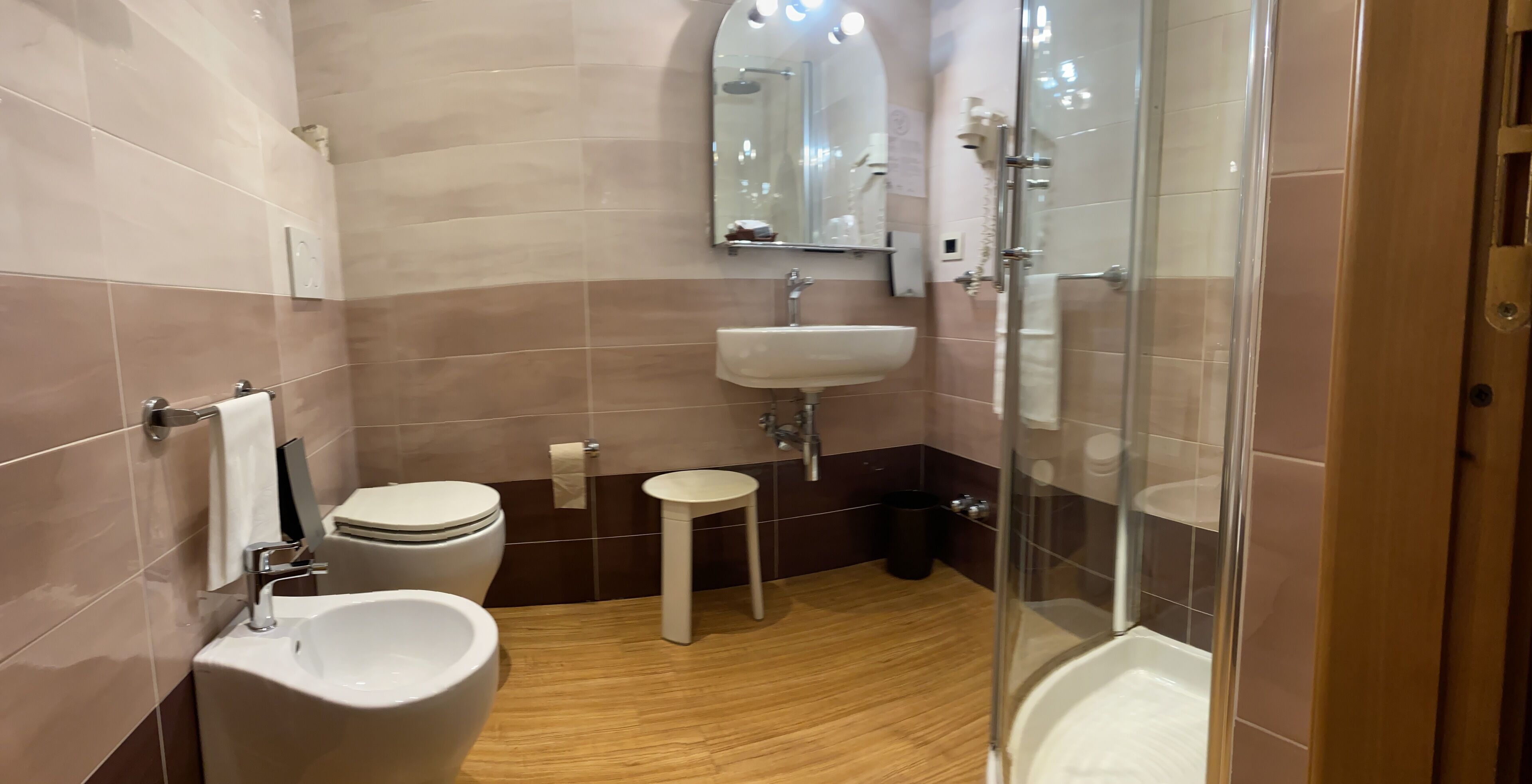 Ein modernes Badezimmer mit Toilette, Bidet, Waschbecken und Dusche.