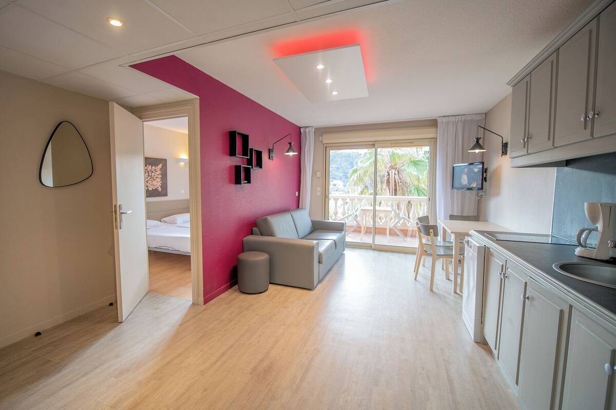 A modern apartment with a kitchen, dining area, and a living room with a sofa and a coffee table.