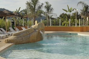 Una piscina al aire libre de temporada, tumbonas