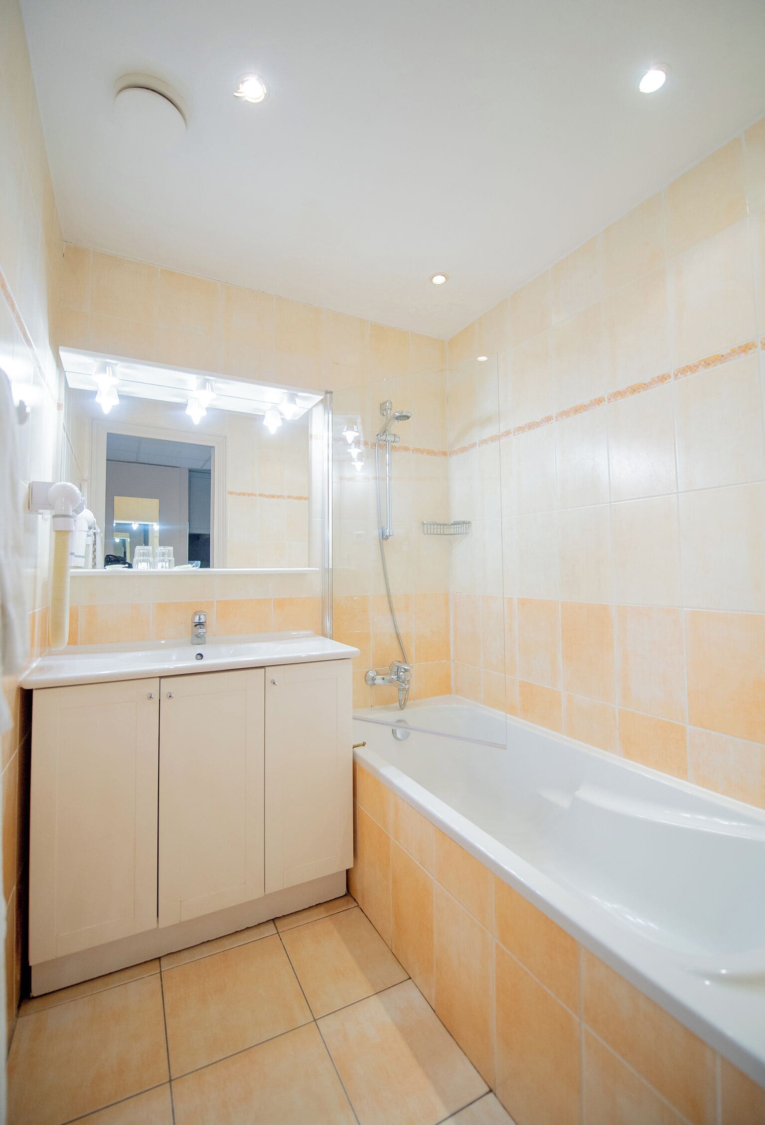 Une salle de bain avec une baignoire, un lavabo et un miroir.