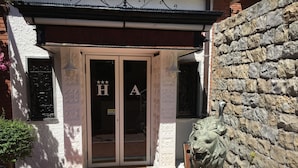 A hotel entrance with a lion statue, a tiled entrance, and a sign with 'H' and 'A' letters. - Hotel Astoria (Bordighera)