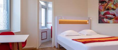 Una habitación de hotel moderna con una cama, un escritorio y una silla.