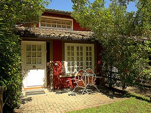 A house with a red exterior, a tiled roof, and a brick pathway leading to the entrance. - Veio Residence Resort (Rome)
