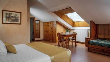 A bedroom with a skylight, a dining area, and a wooden wardrobe.