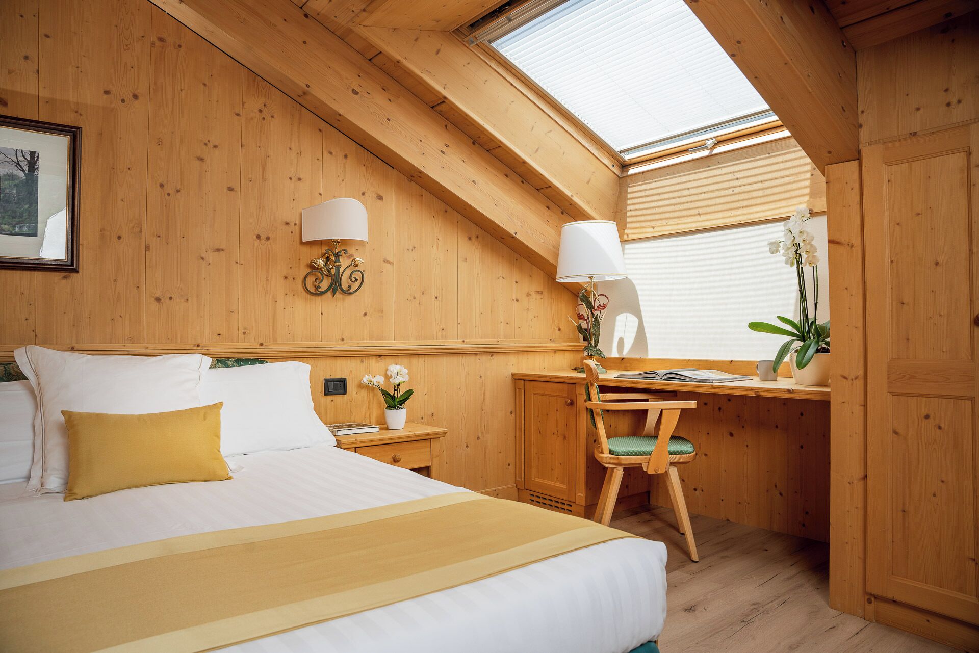 Ein gemütlicher Holzraum mit einem Bett, einem Schreibtisch und einem Stuhl.