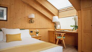 Ein gemütlicher Holzraum mit einem Bett, einem Schreibtisch und einem Stuhl.