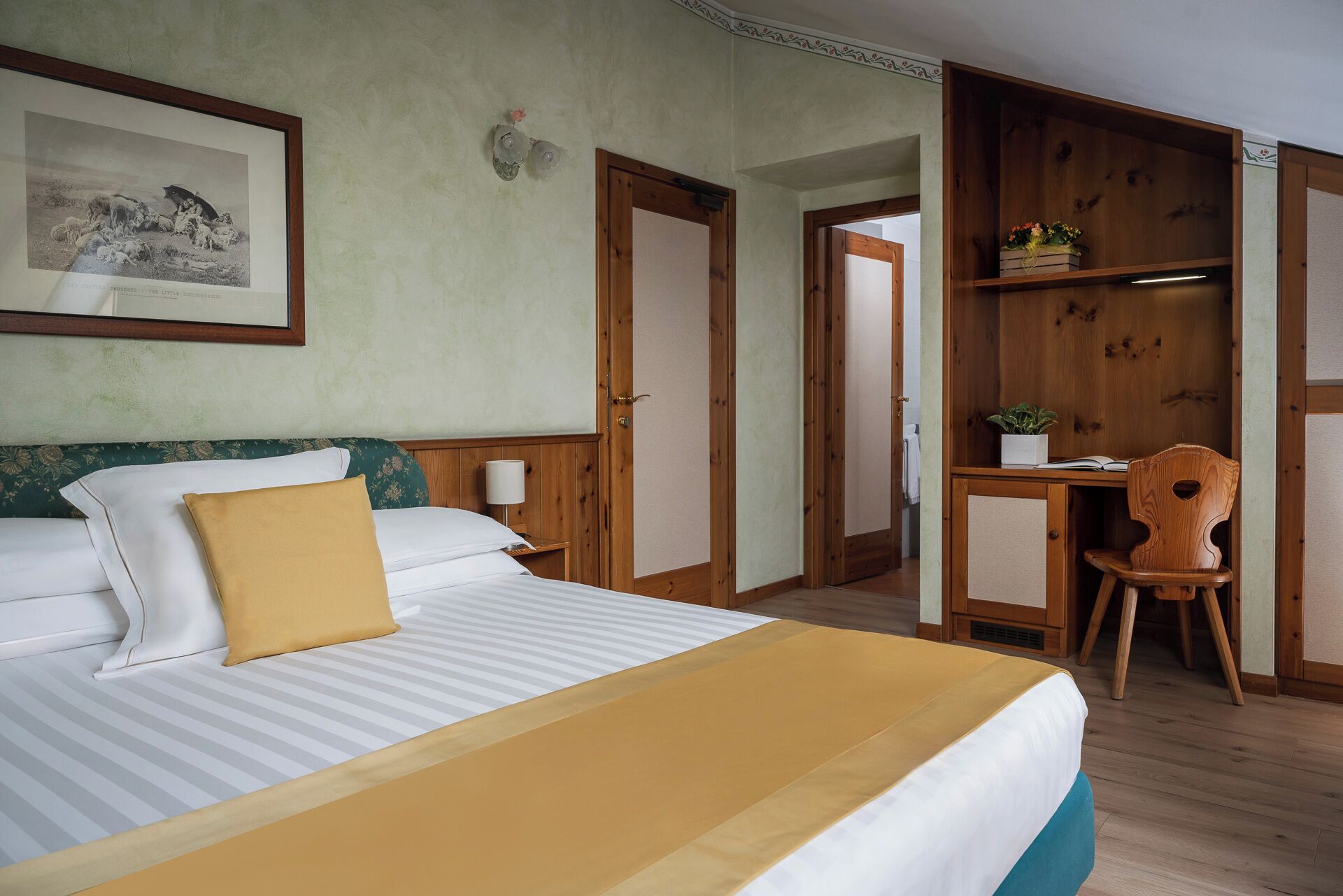Une chambre d’hôtel avec un lit, un bureau et une chaise.