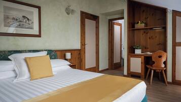 Una camera d'albergo con un letto, una scrivania e una sedia.
