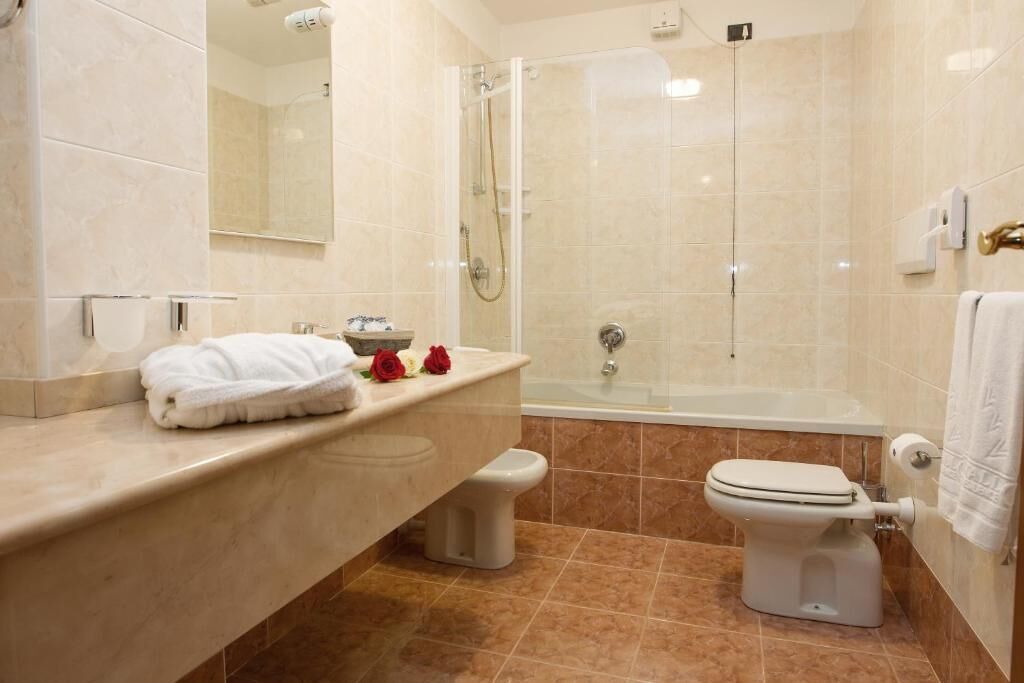 A modern bathroom with a shower, toilet, and sink.