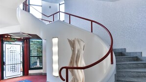 A modern interior with a curved staircase, a red railing, and a large window. - Best Western Hotel Solaf (Medolago)
