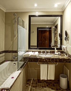 Un baño moderno con una bañera, un espejo grande, un lavabo y una ducha.