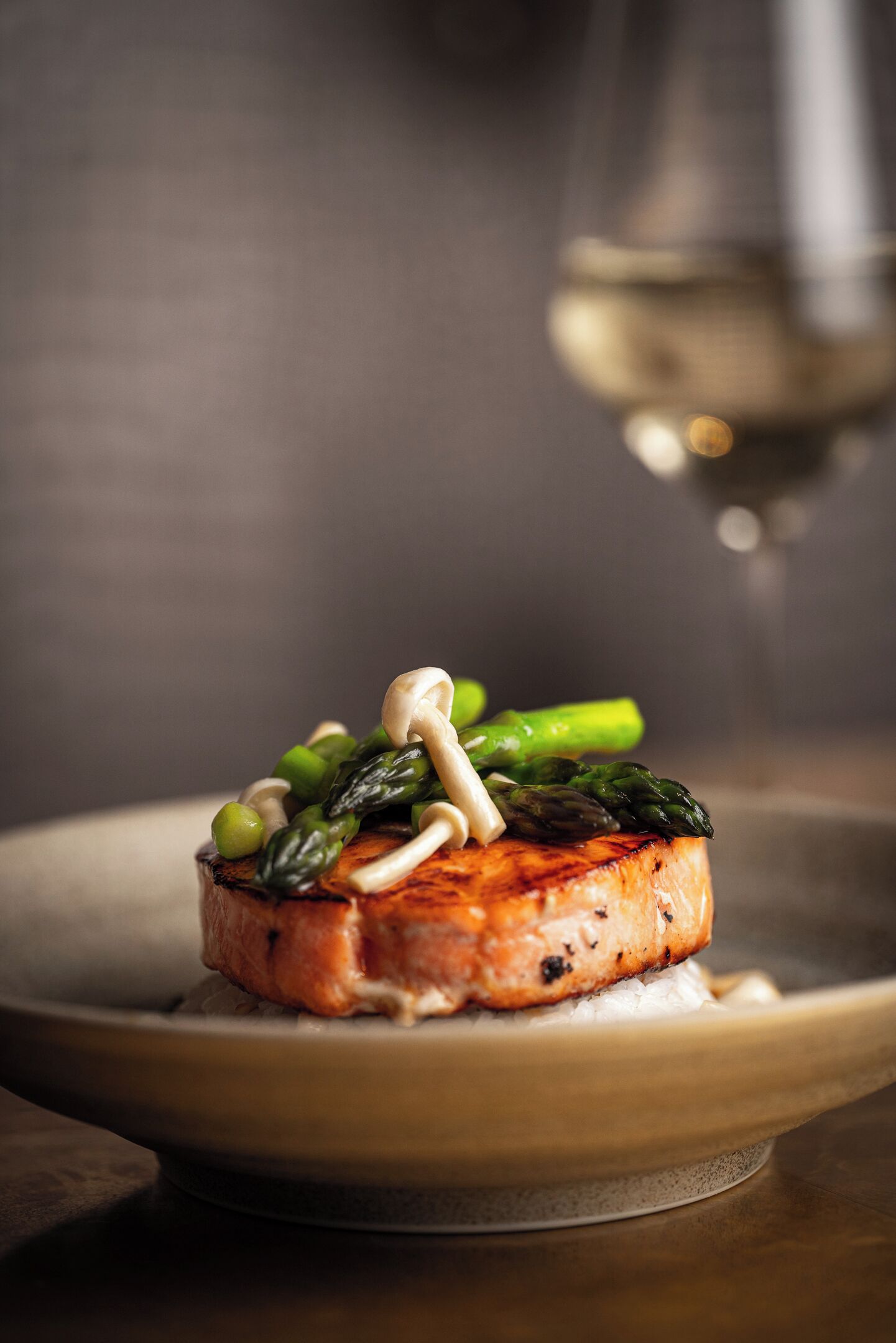 A plate with grilled salmon, asparagus, and mushrooms.
