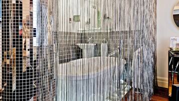 Bathroom features a large round bathtub, separate shower area, and a glass partition for added privacy.