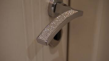 A bathroom door handle with a metallic finish and a diamond-studded design.