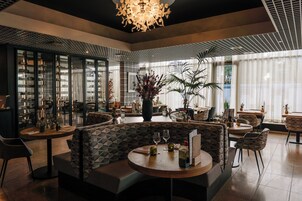 A modern interior with a central seating area, glass partitions, and a decorative ceiling light.