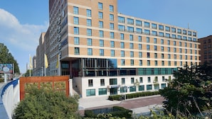 Un hotel moderno con un Skybar destacado en la planta superior, varios balcones y una vista despejada del entorno.