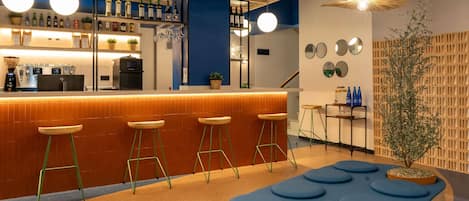 A bar area with stools, a counter, and a plant.
