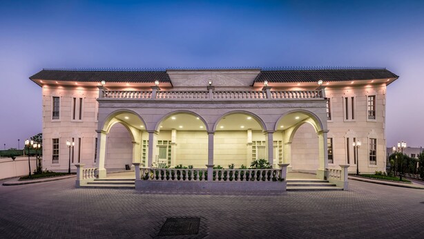 A large, well-lit building with a symmetrical facade, multiple arches, and a central entrance.