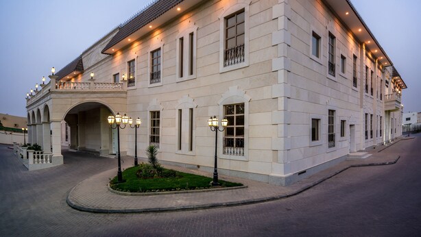 A large, light-colored building with a tiled roof, multiple windows, and a covered entrance. - Holiday Inn Riyadh Izdihar by IHG (Riyadh)