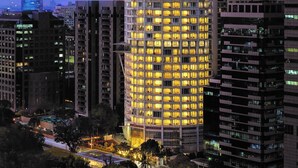 A high-rise building with multiple floors, featuring a modern architectural design with a curved facade and numerous windows.