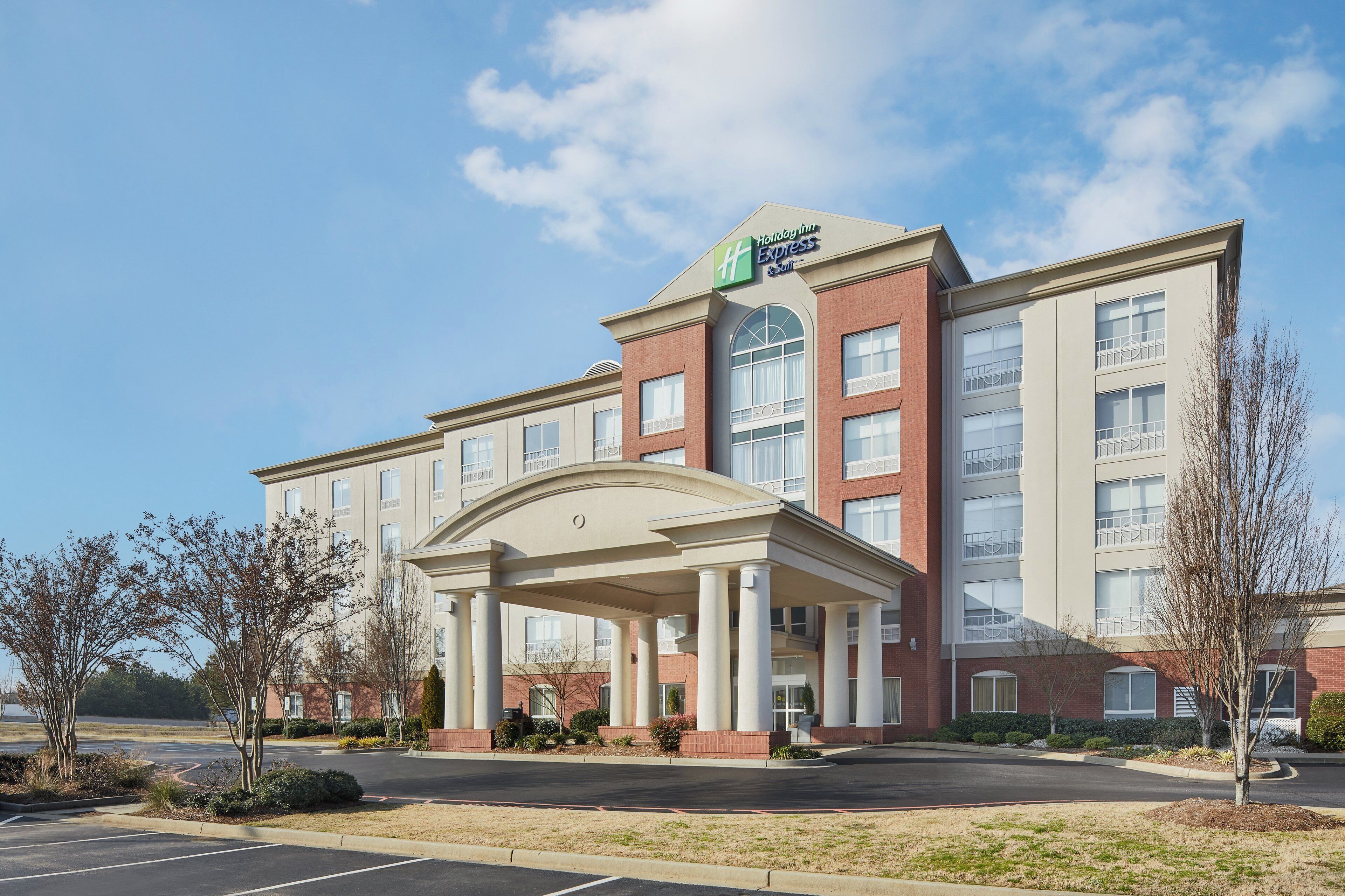 A Holiday Inn Express hotel with a central entrance, multiple floors, and a parking lot.
