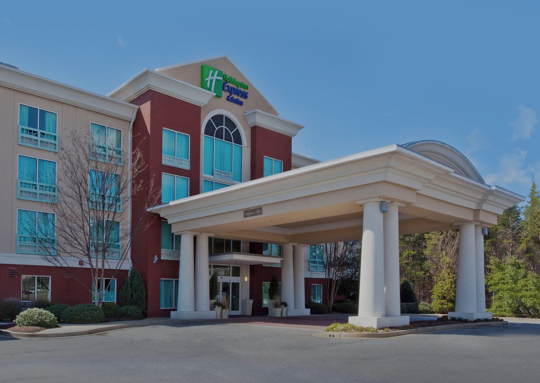 A hotel with a covered entrance, large windows, and a sign for Holiday Inn Express.