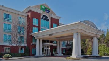 A hotel with a covered entrance, large windows, and a sign for Holiday Inn Express.