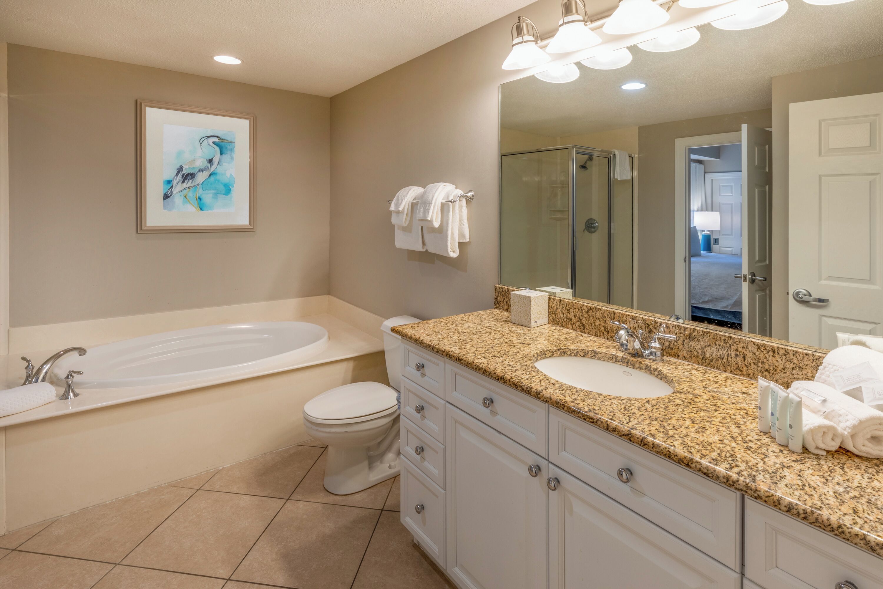 A modern bathroom with a large bathtub, a double sink vanity, and a toilet.