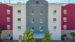 A hotel with a central entrance, multiple windows, and a sign reading 'CANDLEWOOD SUITES'. - Candlewood Suites San Antonio Downtown by IHG (San Antonio)