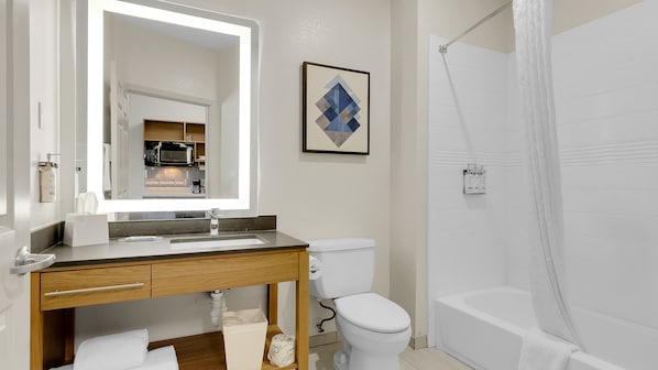 Uma casa de banho moderna com lavatório, sanita e banheira.