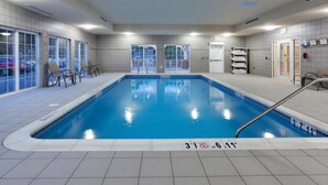Una piscina interior con agua cristalina, marcas de profundidad y suelo de baldosas.